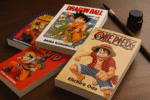 Tomy mang Shonen Jump leżące na biurku obok pędzla i tuszu, symbolizujące klasyczne japońskie komiksy.